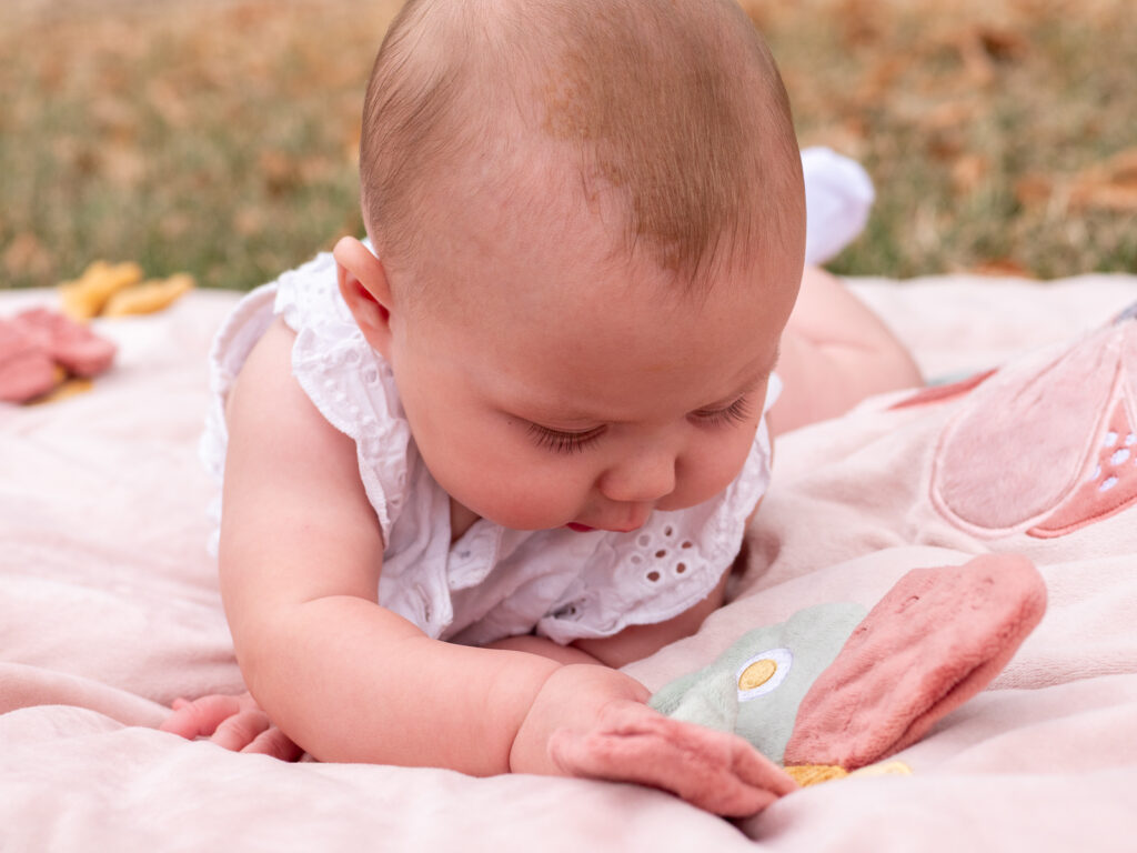 Baby liegt entspannt auf einer Decke bei einem Outdoor-Fotoshooting in der Natur in Bonn