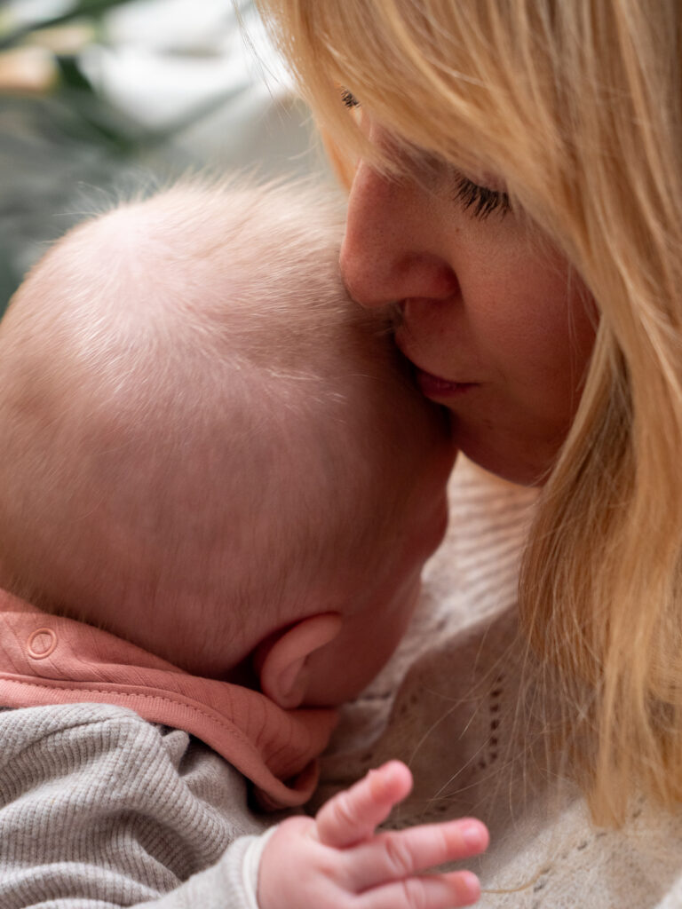 Mutter gibt ihrem Baby einen Kuss auf den Kopf bei einem innigen Moment beim Fotoshooting in Bonn