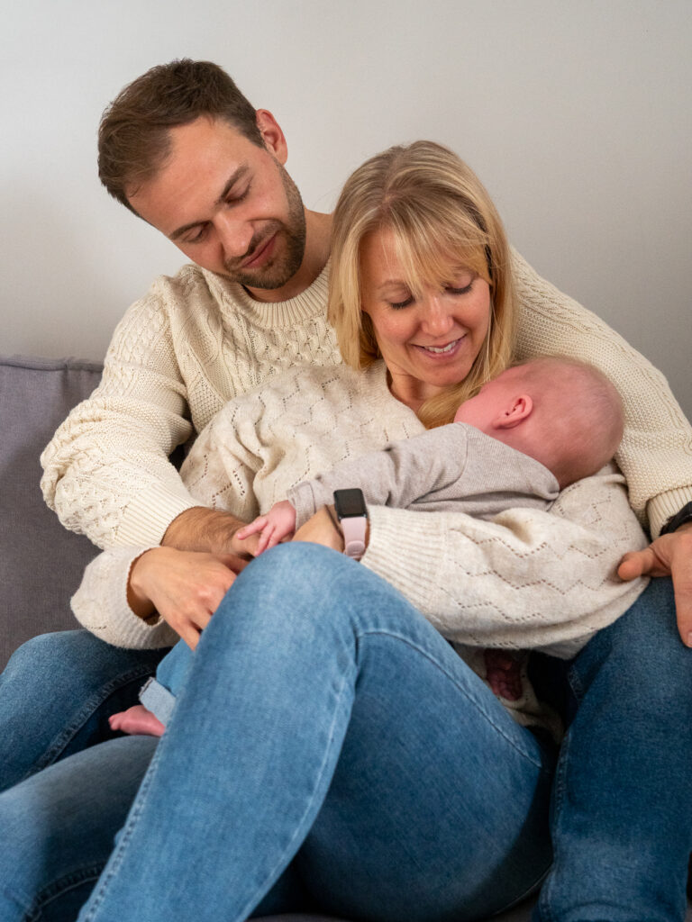 Glückliche Familie mit Baby auf dem Sofa bei einem liebevollen Indoor-Fotoshooting in Bonn