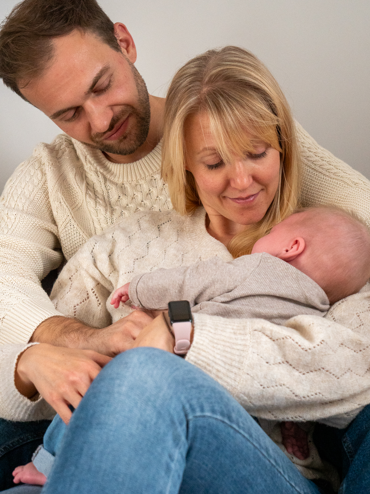 Mama, Papa und Baby gemeinsam auf dem Sofa bei einem natürlichen Familienshooting zu Hause in Bonn