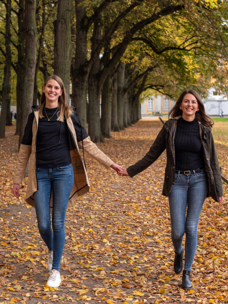 Zwei Freundinnen spazieren im Park beim Fotoshooting im Herbst in Bonn