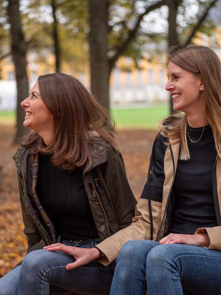 Freundinnen lachen gemeinsam bei einem herbstlichen Outdoor-Fotoshooting in Bonn