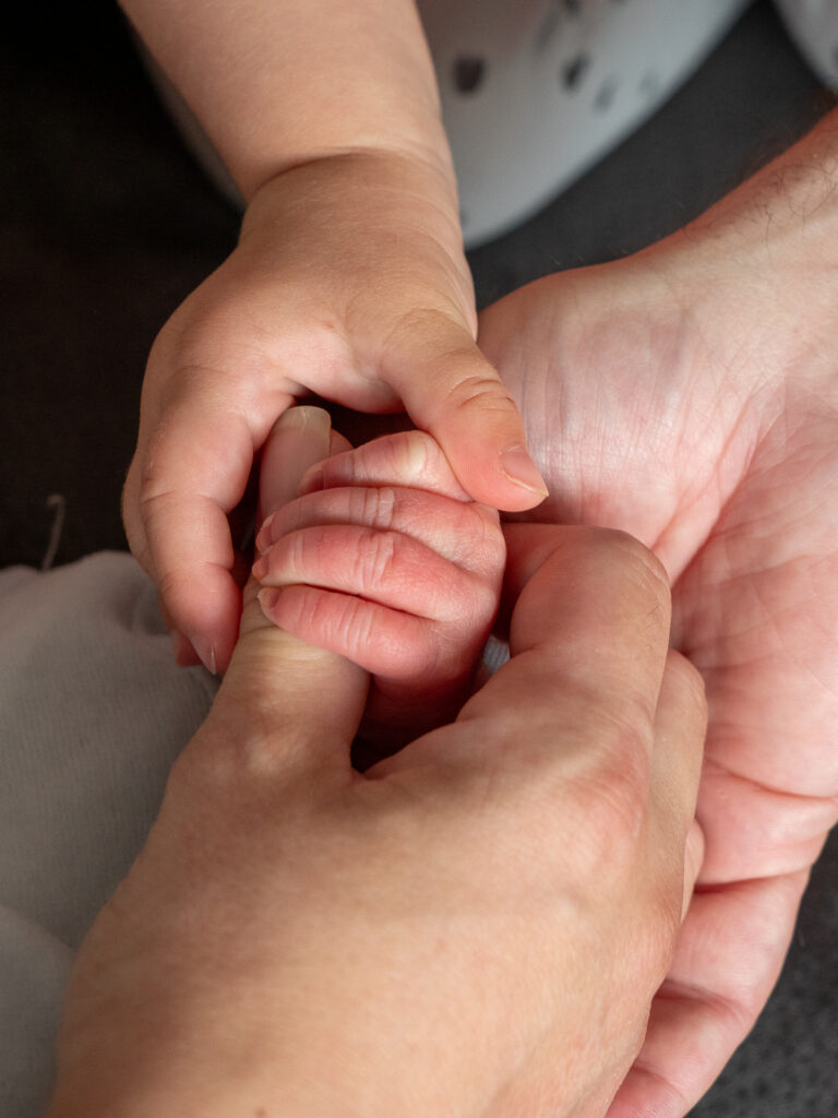 Die Hände einer Familie beim Neugeborenen Fotoshooting in Bonn