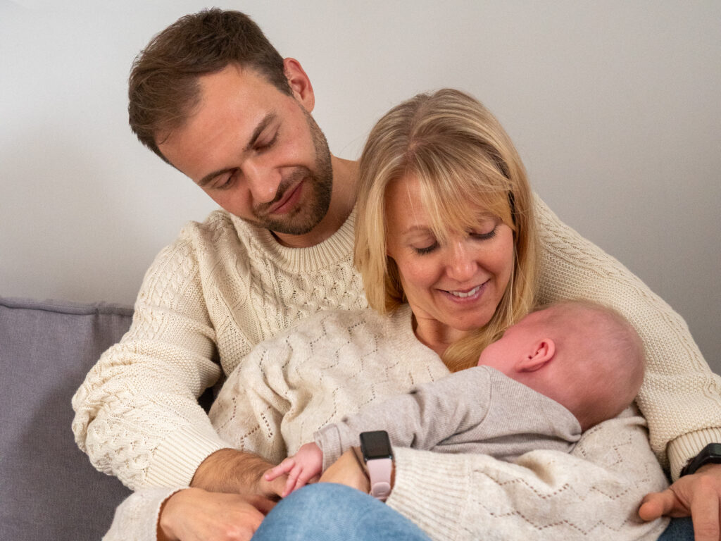 Glückliche Familie mit Baby auf dem Sofa bei einem liebevollen Indoor-Fotoshooting in Bonn